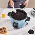 Person adding ingredients to a blue rice cooker on a marble countertop.